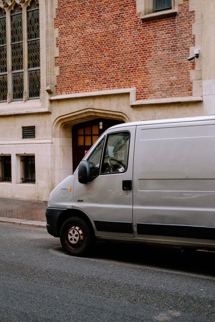 White service van parked outside a building